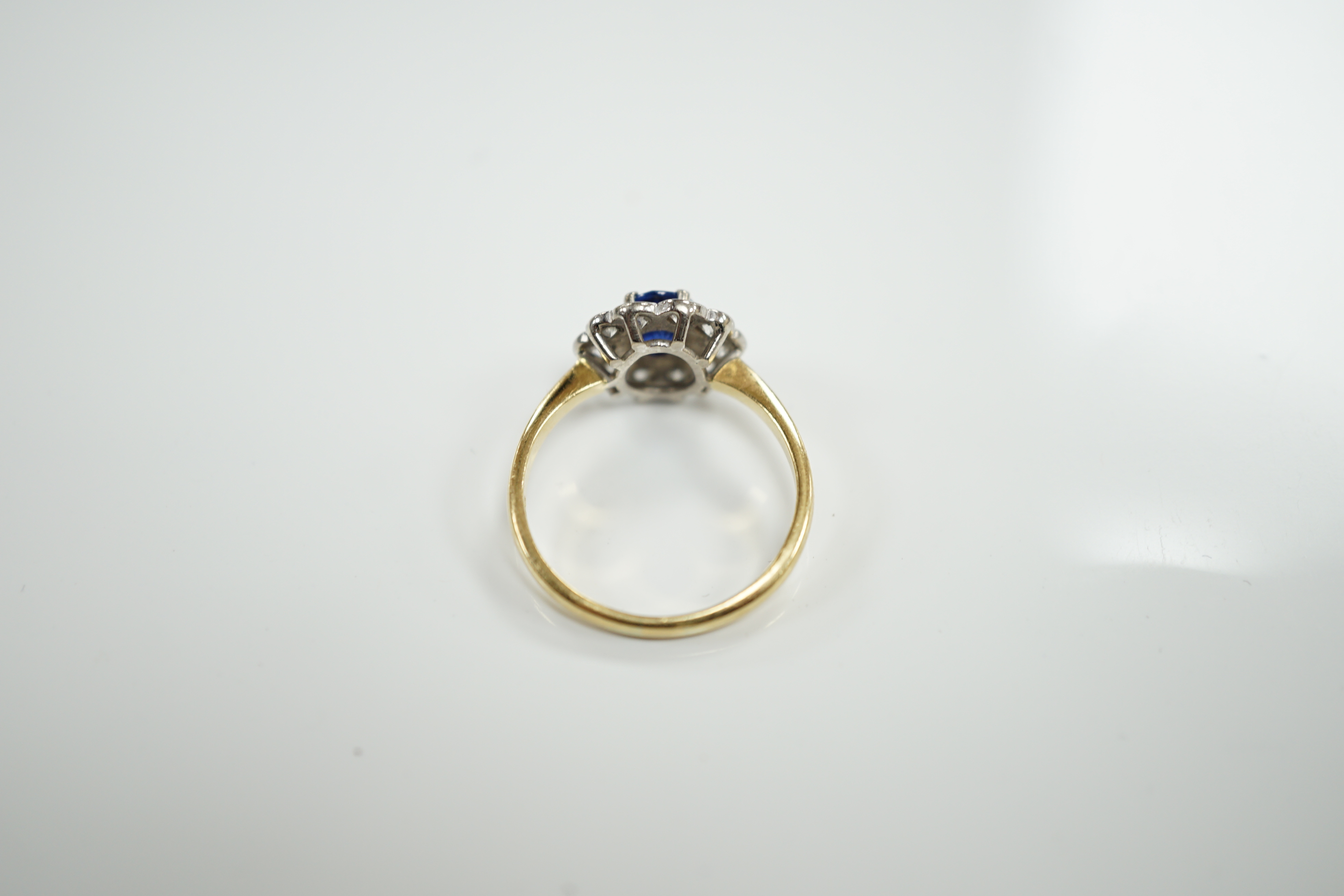 A modern 18ct gold, sapphire and diamond set circular cluster ring, size P/Q, gross weight 3.8 grams.